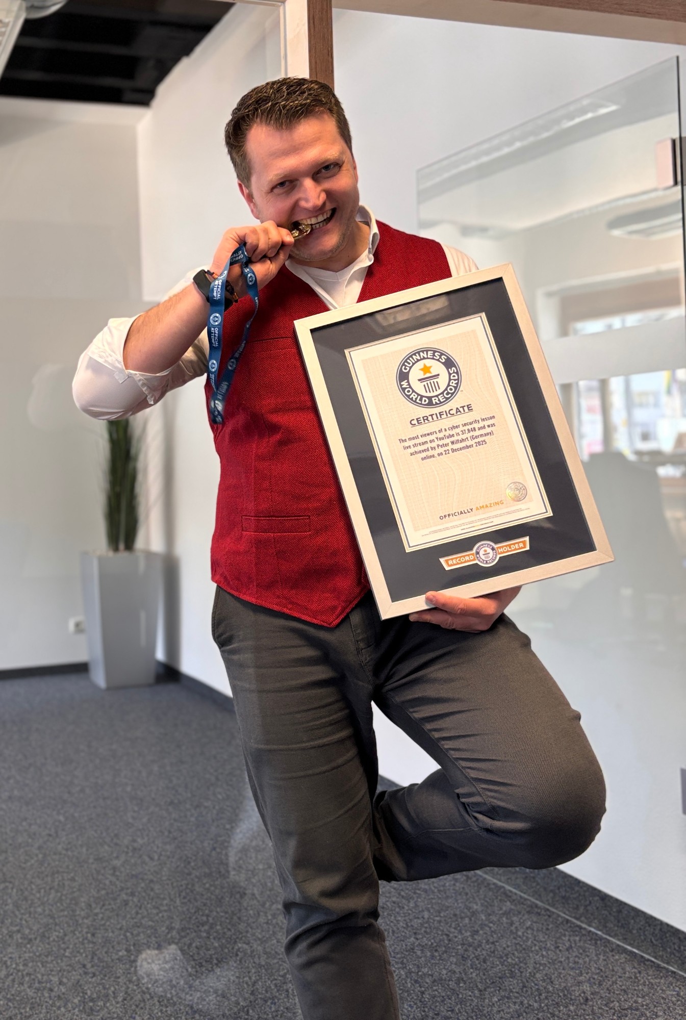 Peter Wilfahrt mit seiner gerahmten Guinness-World-Records-Urkunde für den Cybersecurity-Livestream